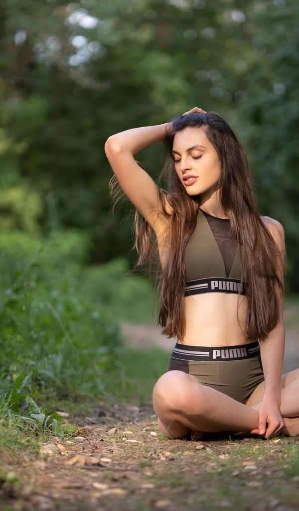 Девушка сидит в позе лотоса в осеннем парке