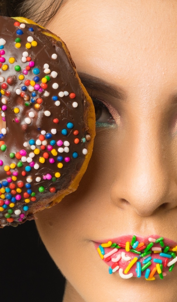 Девушка с пончиком в шоколаде в руках