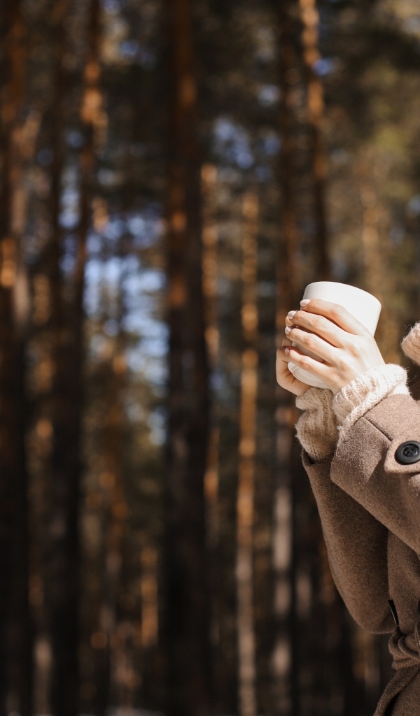 Девушка с чашкой кофе в парке