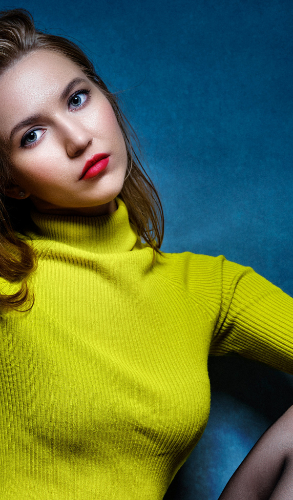 Девушка с рукой в волосах на синем фоне