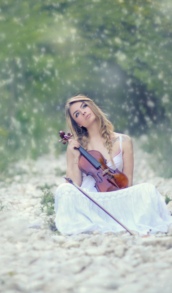 Девушка со скрипкой в руках в лесу