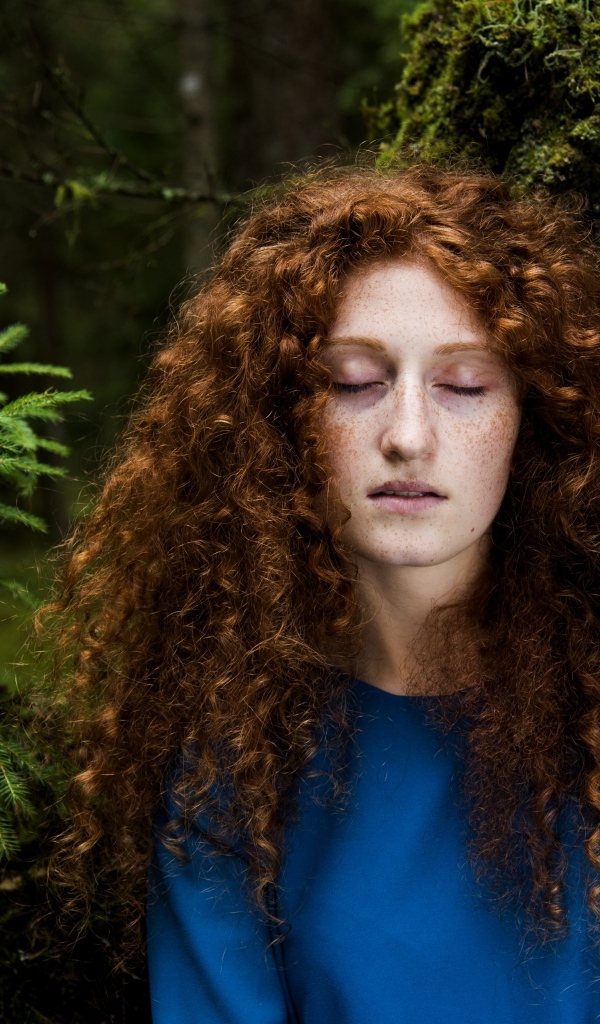 Девушка с кудрявыми волосами в лесу