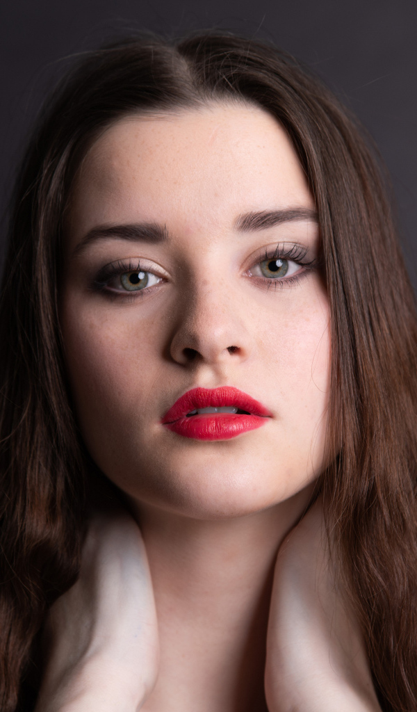 Девушка с красными губами на сером фоне
