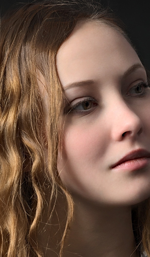 Длинноволосая кареглазая девушка на черном фоне