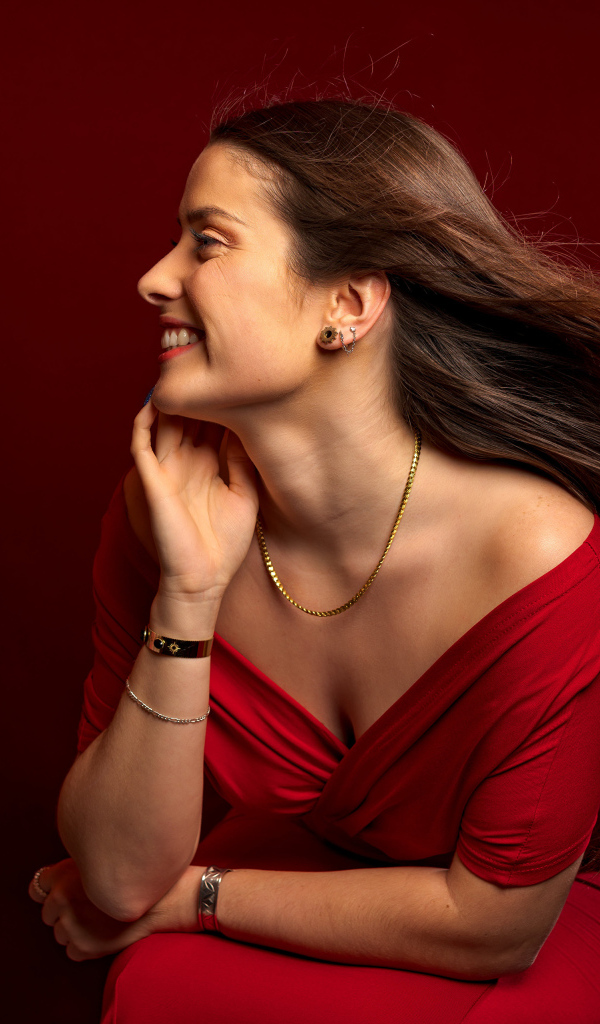 Длинные волосы у красивой девушки в красном платье