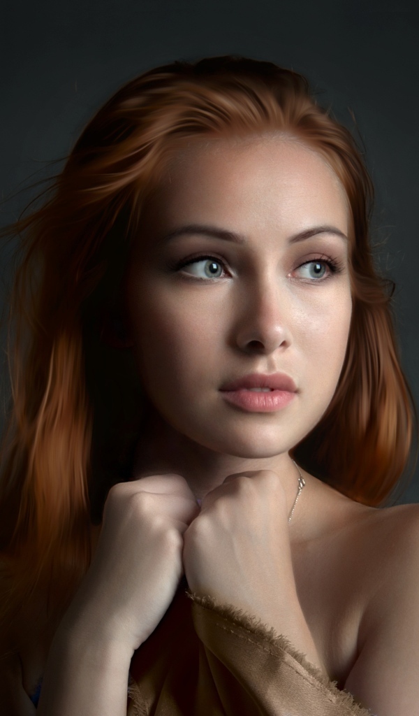 Рыжеволосая девушка с красивыми серыми глазами на сером фоне