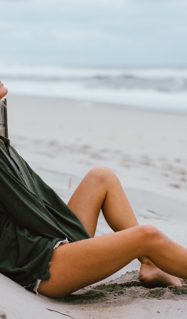 Романтическая девушка лежит на песке у моря