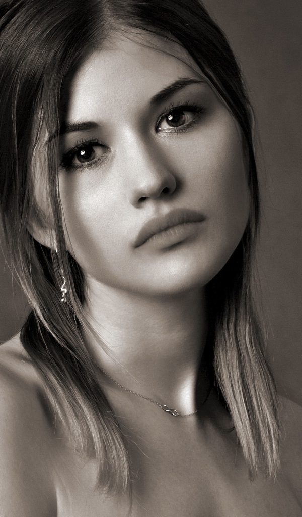 Грустное лицо красивой девушки на сером фоне