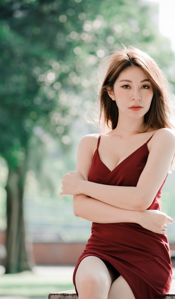 Серьезная девушка азиатка в красном платье