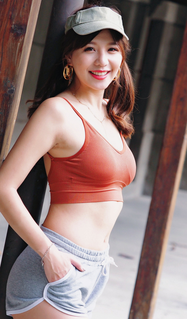 Улыбающаяся девушка азиатка в кепке