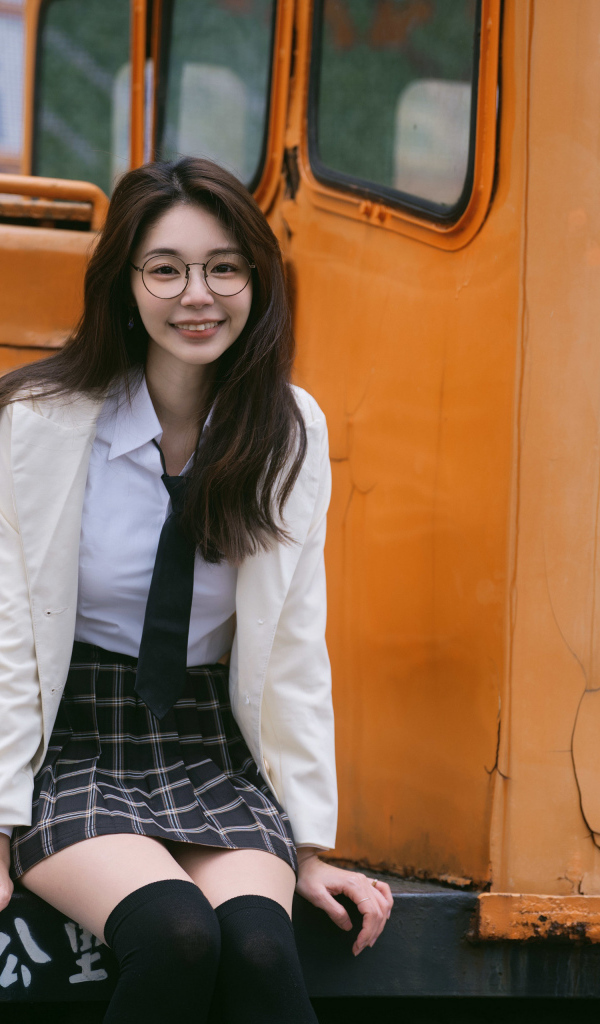 Улыбающаяся девушка азиатка в школьной форме