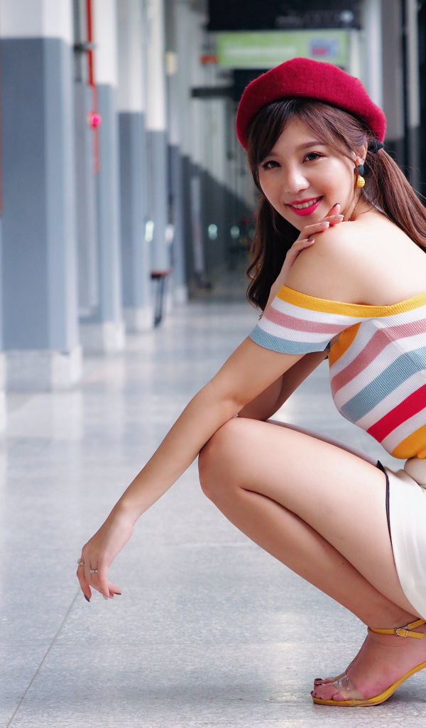 Улыбающаяся азиатка в красном берете