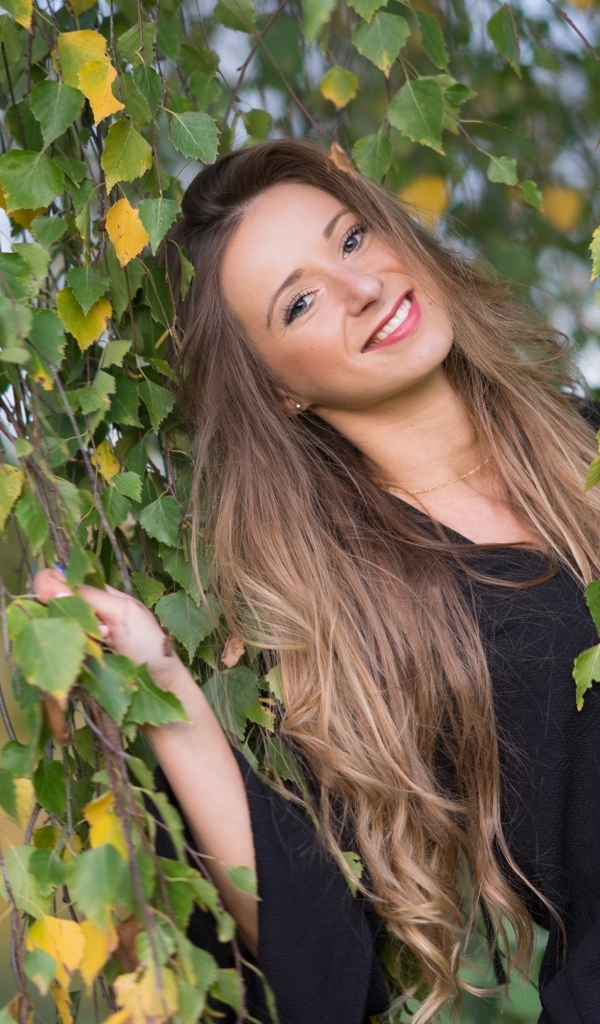 Улыбающаяся девушка в ветках березы