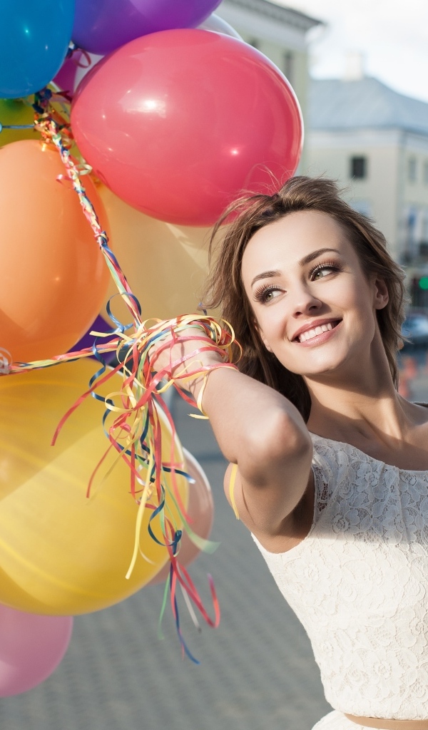 Улыбающаяся девушка с воздушными шариками