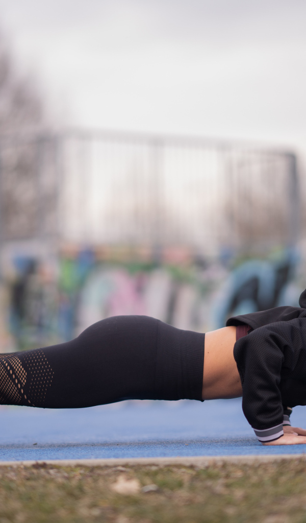 Спортивная девушка отжимается от земли