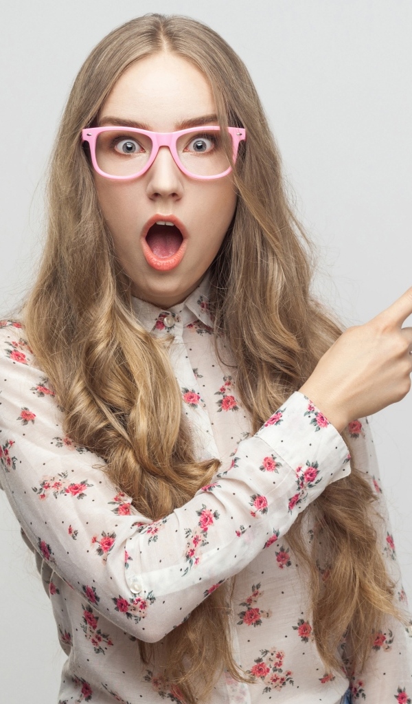 Удивленная девушка на сером фоне