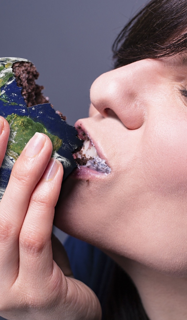 Девушка ест пирожное в виде планеты земля