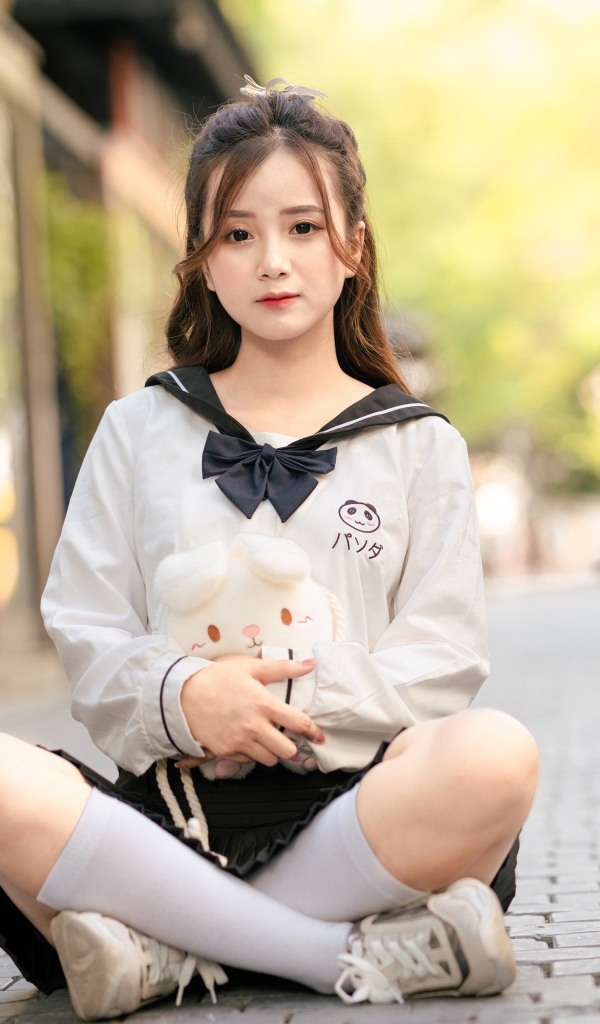 Молодая девушка азиатка сидит в позе лотоса на дороге