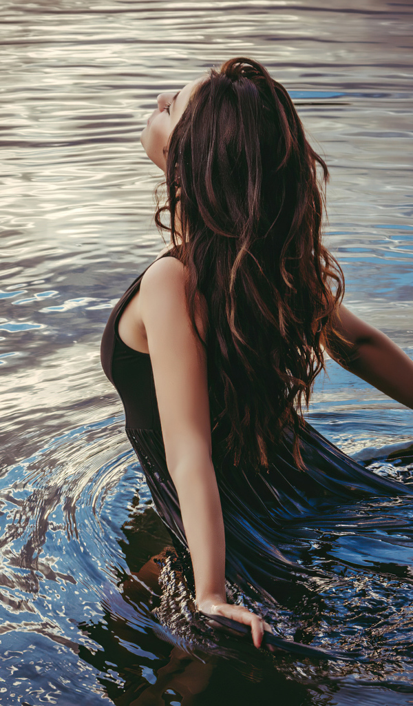 Молодая девушка купается в воде