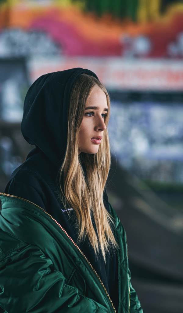 Молодая девушка в зеленой куртке