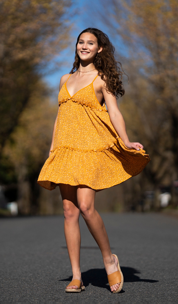 Молодая девушка в коротком платье на дороге  летом