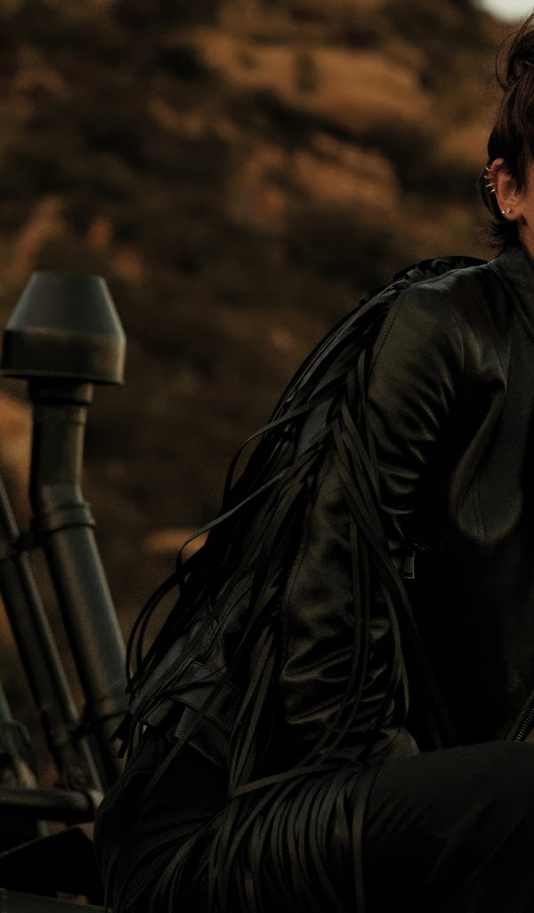 Модель Тейлор Хилл в черной куртке сидит на машине