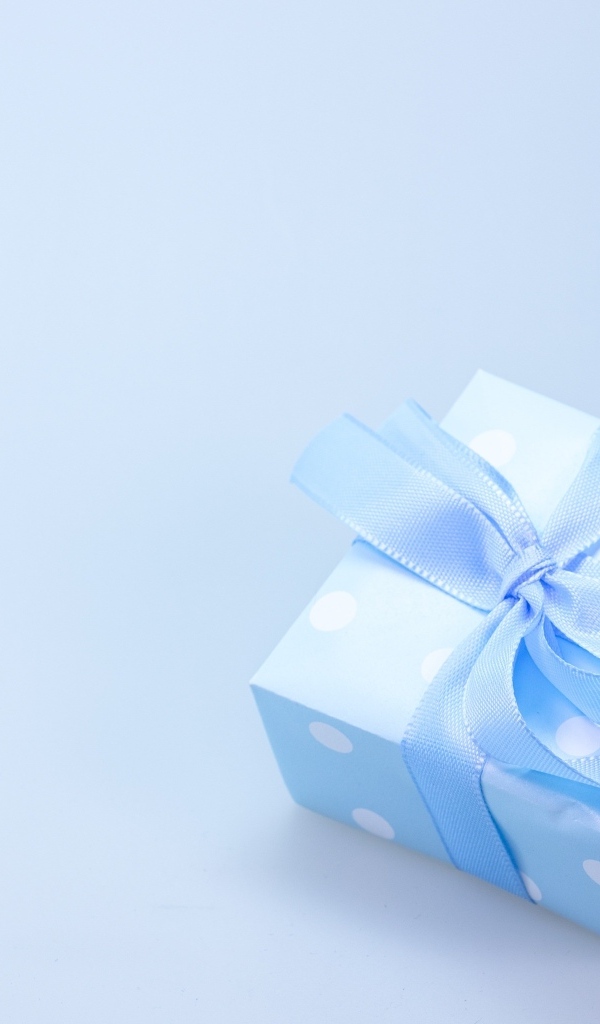 Коробка для подарка с голубой лентой на сером фоне
