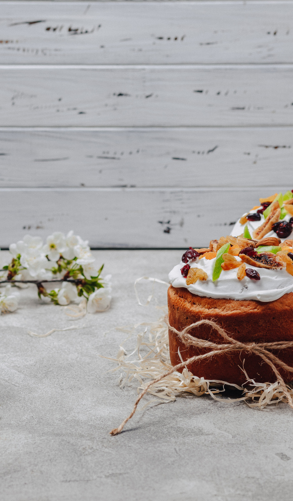 Красивые пасхальные куличи с веткой вишни на сером столе на Пасху