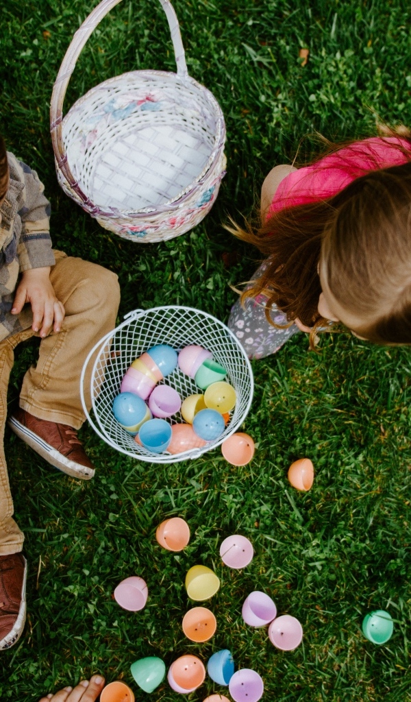 Дети играют на траве с пасхальными яйцами