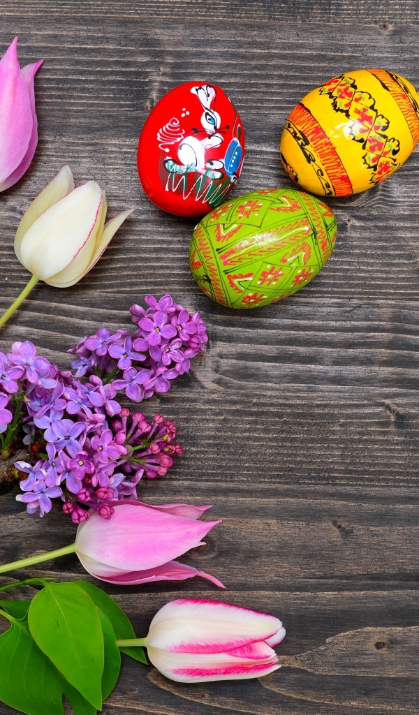 Пасхальные яйца с живыми цветами на столе 