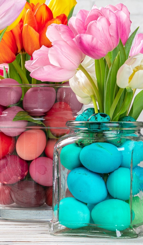 Банки с крашеными яйцами и тюльпанами на Пасху
