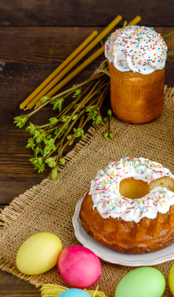 Сладкие пасхальные куличи на столе с чаем и крашеными яйцами