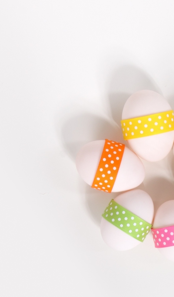 Белые яйца с ленточками на белом фоне