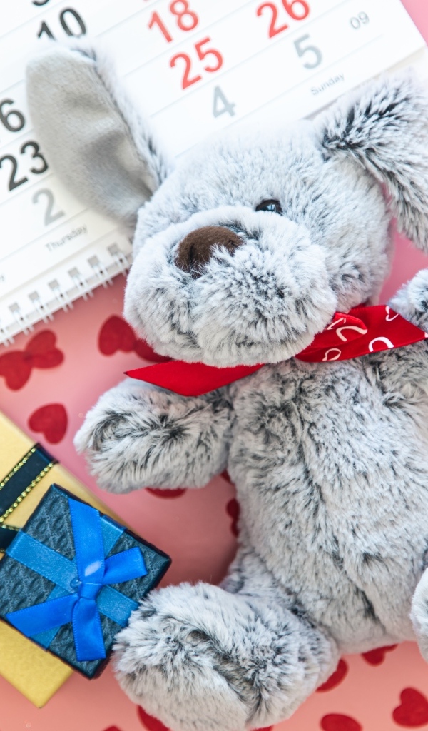 Игрушка и календарь на розовом фоне