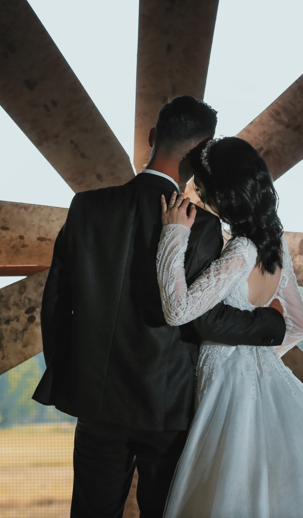 Влюбленные жених и невеста стоят у окна