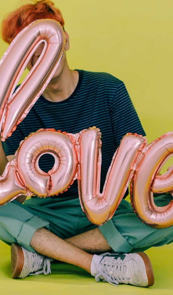 Мужчина держит шарики с надписью любовь