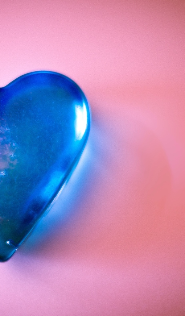 Синее стеклянное сердце на розовом столе