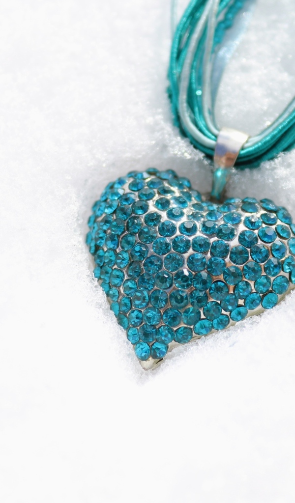 Голубой кулон в форме сердца на снегу