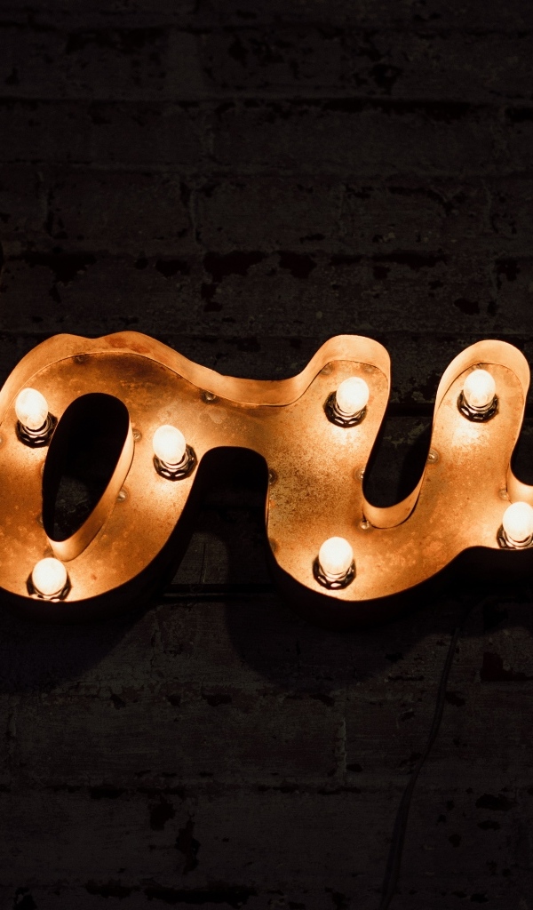 Светящаяся надпись любовь на черной стене