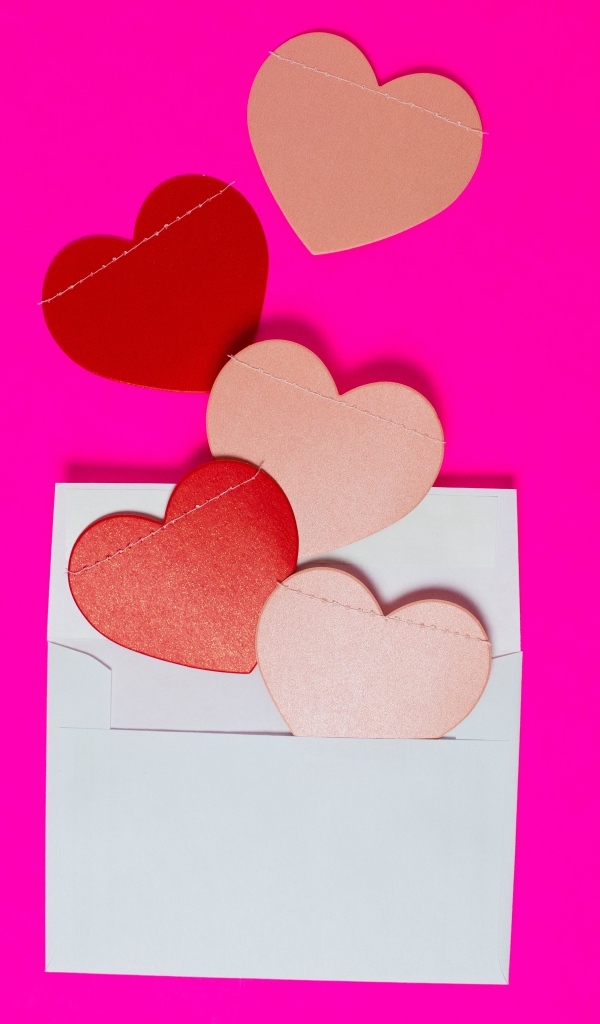 Сердечки с белым конвертом на розовом фоне