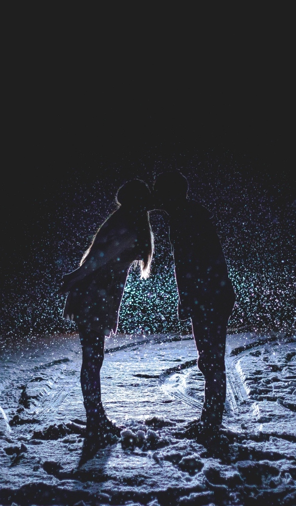 Поцелуй влюбленной пары на снегу ночью