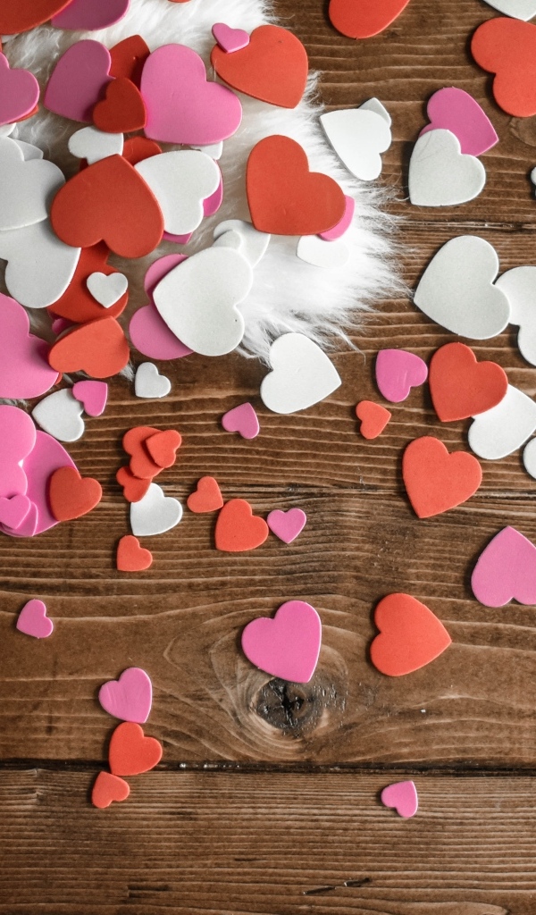 Много бумажных сердечек на деревянном полу