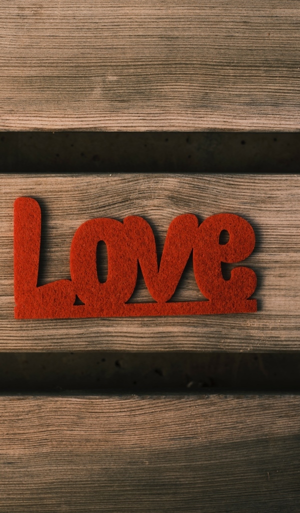Красная надпись любовь на деревянном фоне