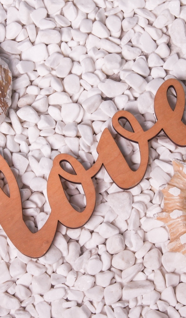 Ракушки и надпись любовь на белых камнях