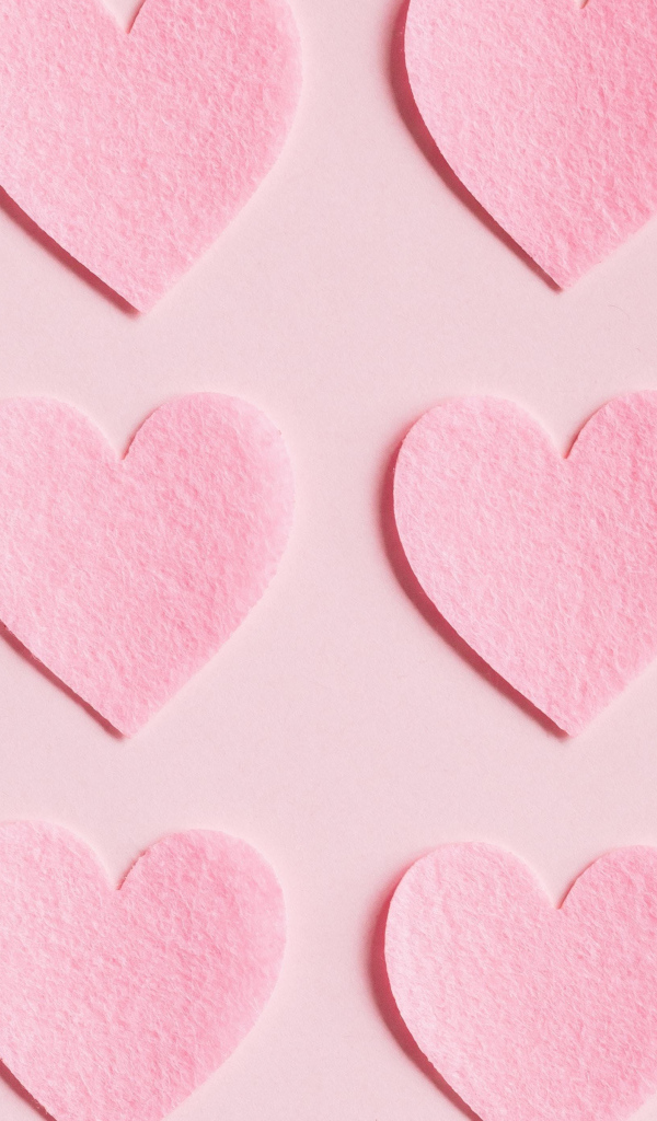 Маленькие бумажные сердечки на розовом фоне