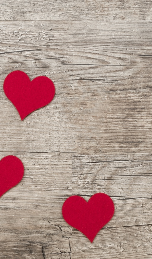 Маленькие красные сердечки на деревянном фоне