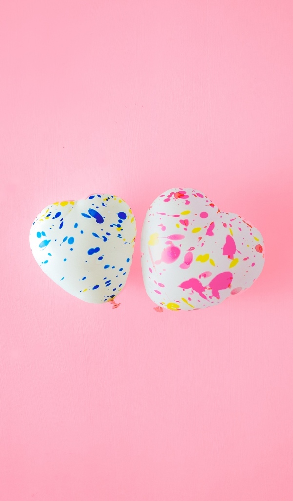 Два шарика в форме сердца на розовом фоне