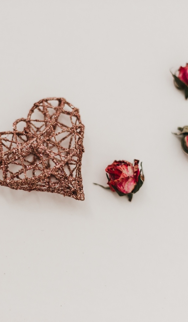 Плетеное сердце с сухими розами на сером фоне