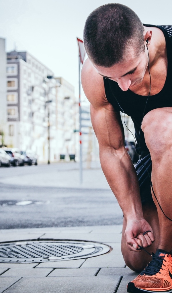 Мужчина спортсмен завязывает шнурки