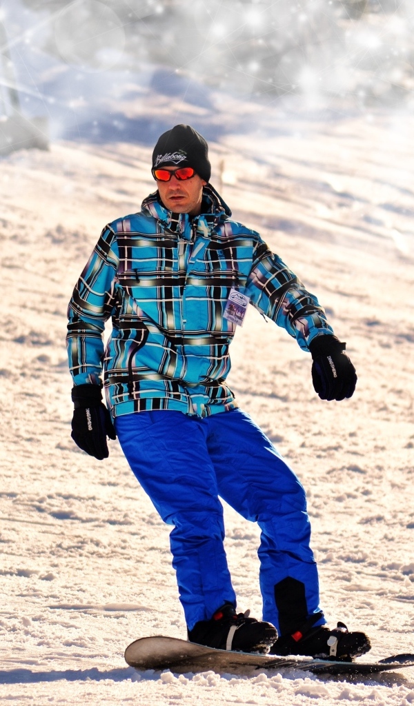 Мужчина сноубордист спускается по склону